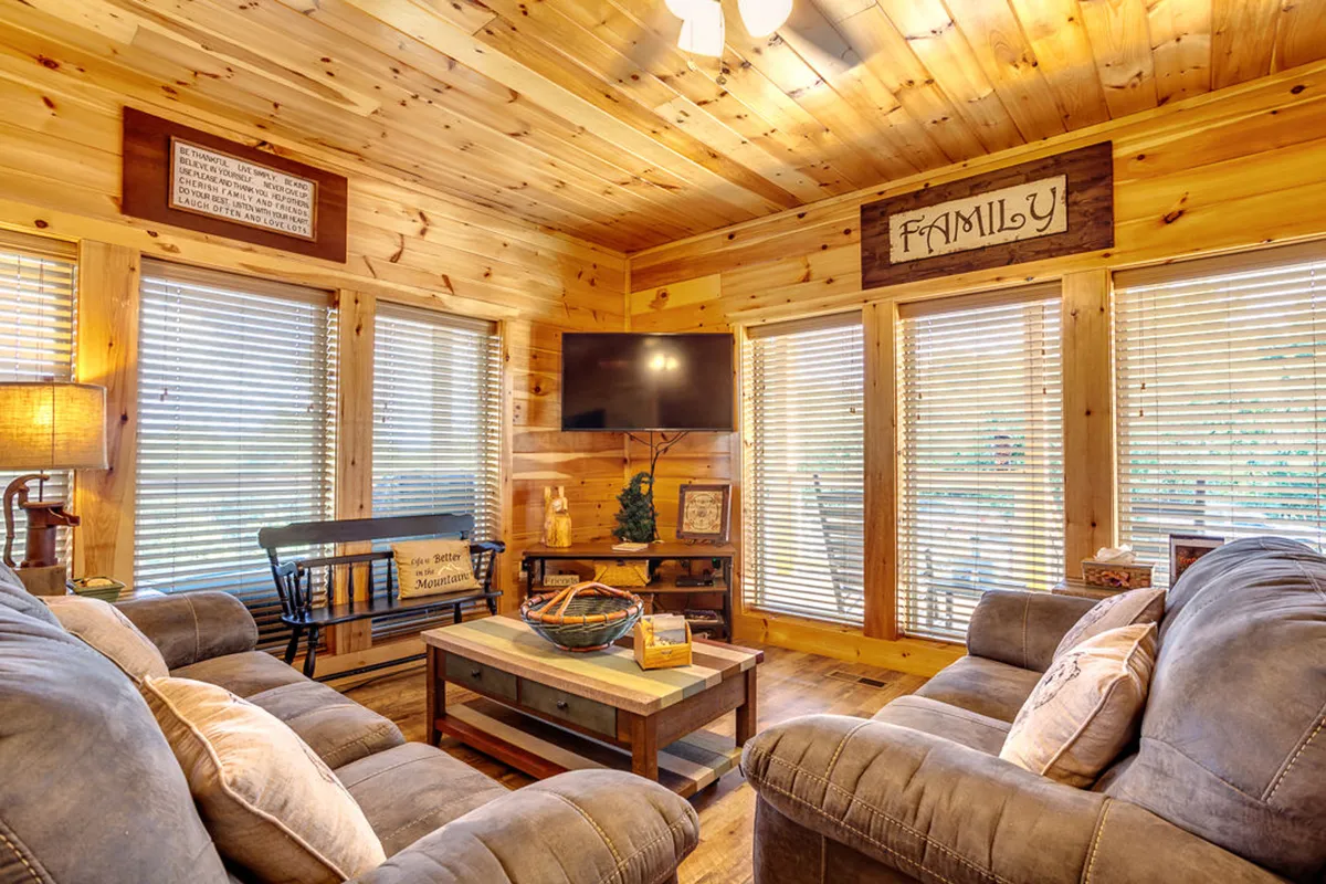 A spacious lounge with comfortable sofas, a wooden coffee table, family-themed decor, and large windows that brighten the room. The mood is cozy and welcoming, ideal for socializing and making memories with friends and family.