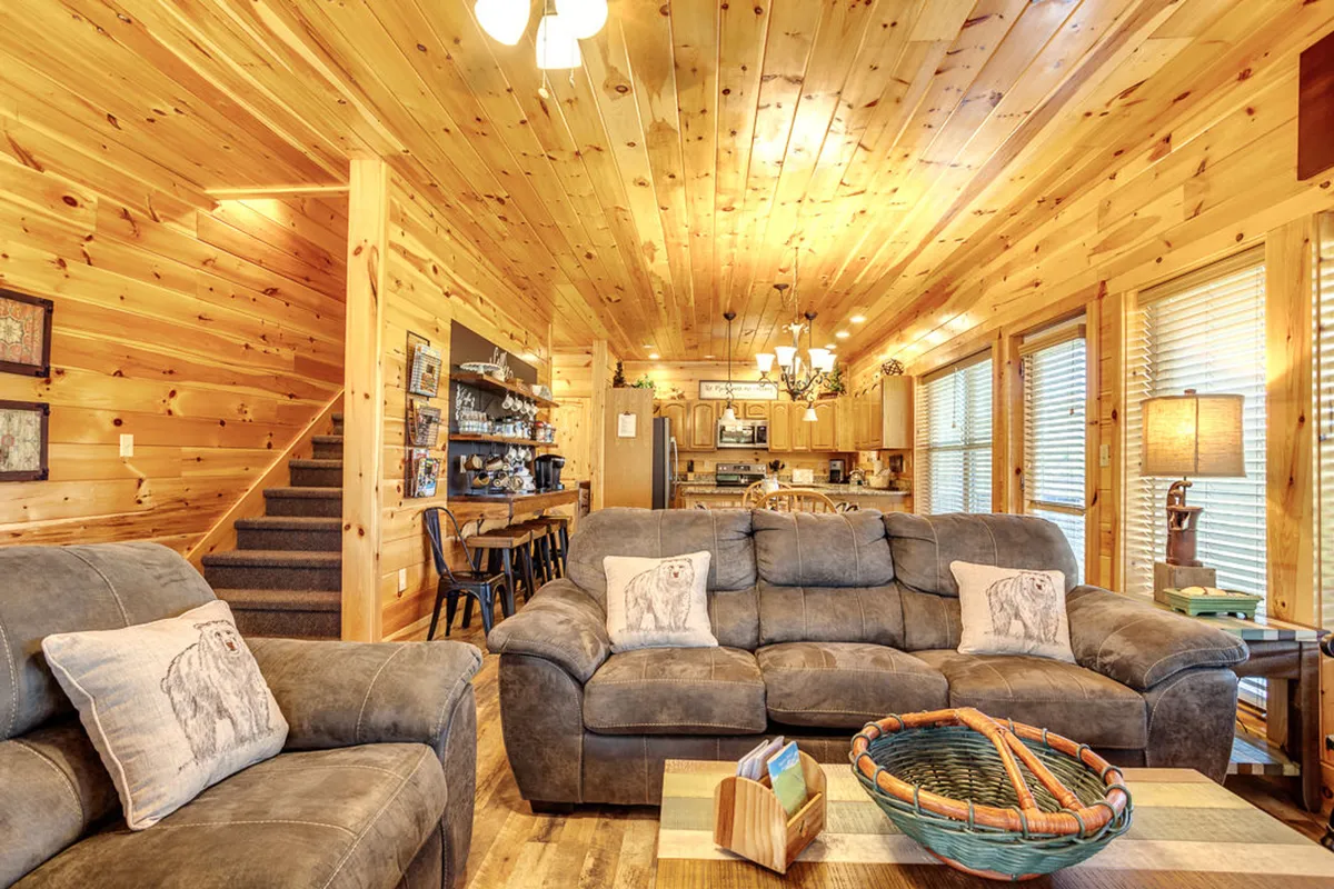This open-plan interior captures the dining area aglow with natural light, comfortable seating, and a view of the adjacent kitchen. The atmosphere is warm and welcoming, ideal for festive meals and group gatherings.